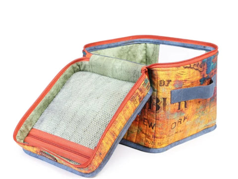 Open fabric storage bin with a mesh zippered lid and a colorful, distressed text pattern.