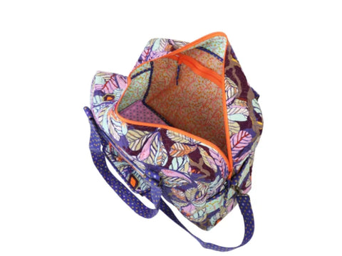 A colorful duffle bag with a leaf pattern and orange zipper is open, revealing its interior.
