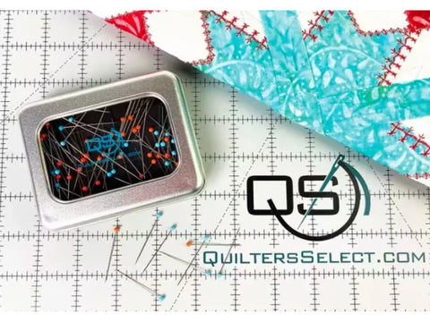 Quilters Select Magnetic Pin Tin with 100 glass head pins on a white grid mat.