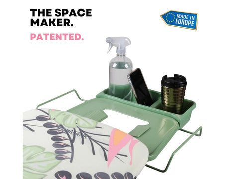 Ironing board with a tropical green cover and an attached accessory tray.