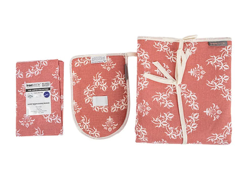 A pink ironing mat and steam glove with white floral patterns.