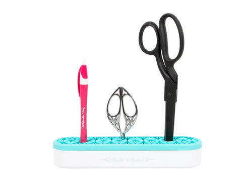 An aqua Stash N' Store organizer holds a pink pen, small silver scissors, and large black scissors.