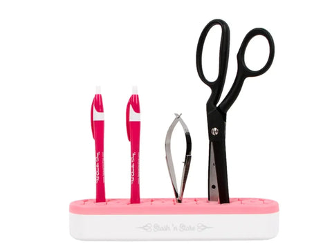 Pink and white Stash 'n Store organizer holding two pens, tweezers, and scissors.
