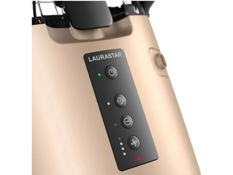 Close-up of a gold Laurastar ironing system control panel with black buttons and a green indicator light.
