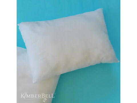 Kimberbell 12x18 inch white rectangular pillow insert on a blue background.