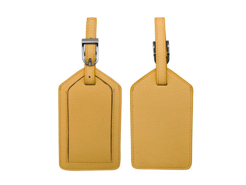Two yellow leather luggage tags, one showing the front with a buckle, and one showing the back.