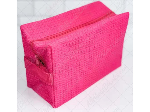 Hot pink waffle weave cosmetic bag with a zipper closure.