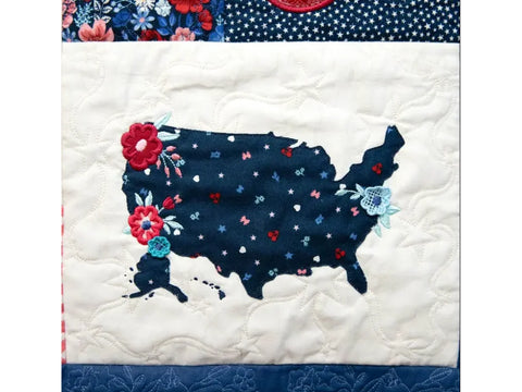A quilted fabric block features a dark blue map of the USA with floral accents.