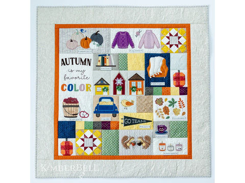 A quilted wall hanging featuring various autumn-themed embroidered blocks.