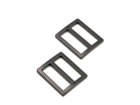 Two black metal 1-inch sliders are angled on a white background.