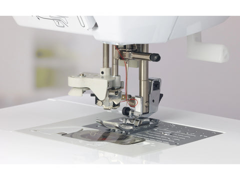 A close-up of the needle and presser foot area of a white Baby Lock Lyric sewing machine.