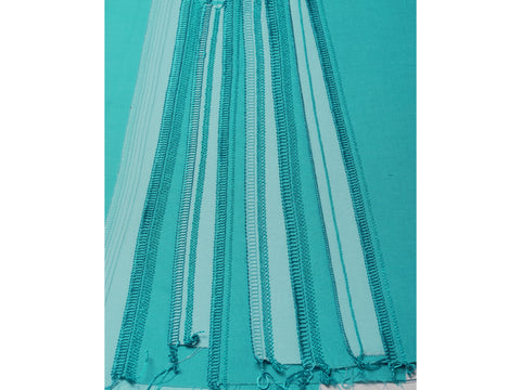 A close-up of various teal and light blue serger stitches on fabric.