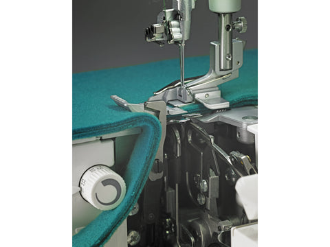 Close-up of a Baby Lock Triumph serger with teal fabric under the needle.