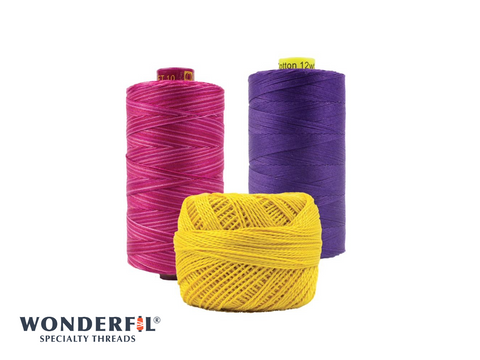 Three spools of WonderFil thread, one pink, one purple, and one yellow.