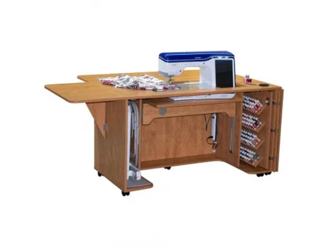 A light wood sewing and embroidery cabinet with a sewing machine, fabric, and thread.