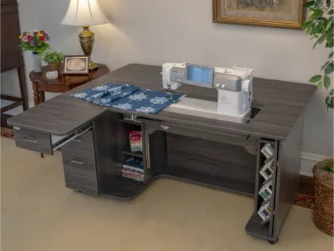 A gray sewing and embroidery cabinet with an open drawer and hoop storage.