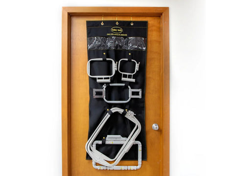 Baby Lock over-the-door frame organizer with various embroidery hoops on a wooden door.