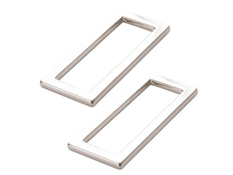 Two nickel-plated rectangular rings are angled on a white background.