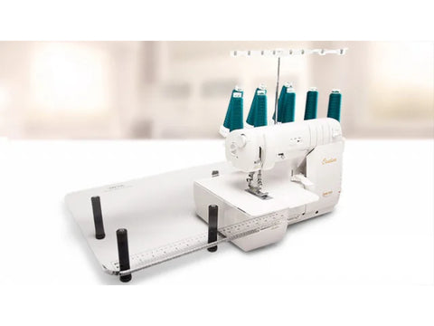 A white Baby Lock sewing machine with an acrylic extension table and teal thread spools.
