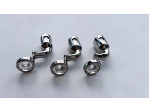 Three silver couching feet for sewing machines are arranged on a white surface.