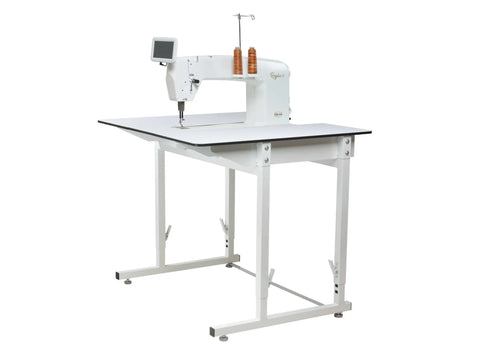 A white Baby Lock 20" Regalia stationary quilting machine on a white standard table.