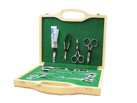 A 9-piece scissor set in a wooden box with a green felt interior.