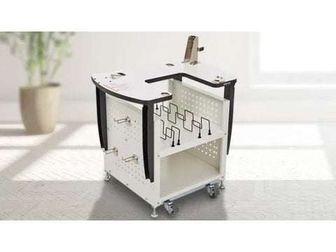 White embroidery machine stand with storage, on wheels, in a bright room.