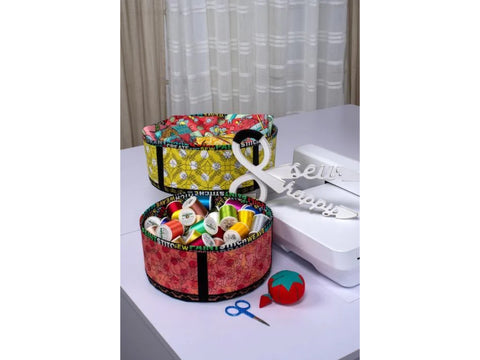 Two round fabric bins, one yellow and one red, filled with colorful spools of thread.