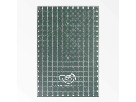 A green Quilters Select dual-sided cutting mat with white grid lines and measurements.