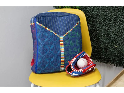 A blue quilted backpack with colorful stripes and a baseball glove with a ball.