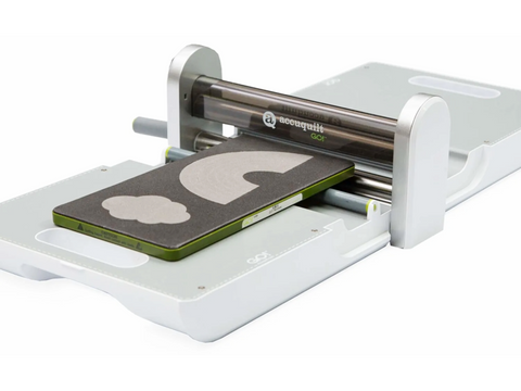 A white AccuQuilt GO! fabric cutter with a rainbow and cloud die.