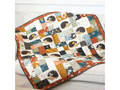A quilted blanket with hedgehog appliques and various patterned fabric squares.