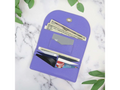 A purple faux leather wallet with cash and cards inside, on a marble surface with green leaves.