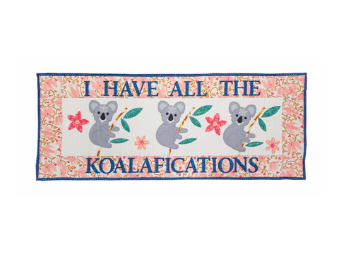 A rectangular quilt features three koalas and the phrase "I HAVE ALL THE KOALAFICATIONS".