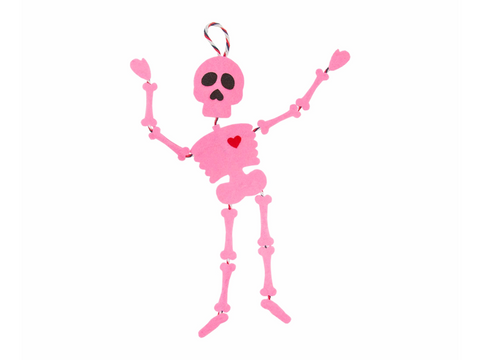 A pink felt skeleton with black eyes and a red heart on its chest.