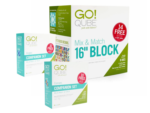 Three AccuQuilt Qube fabric cutting system boxes are displayed, with the largest box in the background.