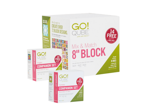 Three AccuQuilt Qube boxes are stacked, with the largest "Mix & Match 8" Block" box at the back.