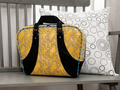 Yellow and black bag with anchor pattern and a white pillow with black circles.