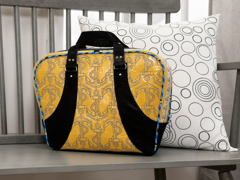 Yellow and black bag with anchor pattern and a white pillow with black circles.