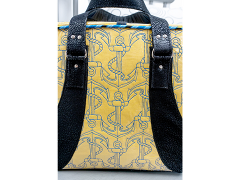 Yellow bag with blue anchor pattern and black straps.