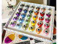 A box of 30 Floriani embroidery thread spools in various colors.