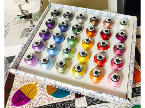 A box of 30 Floriani embroidery thread spools in various colors.