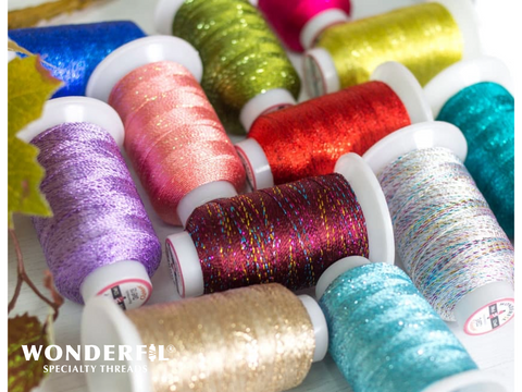 A collection of colorful, glittery Wonderfil Glamore thread spools.