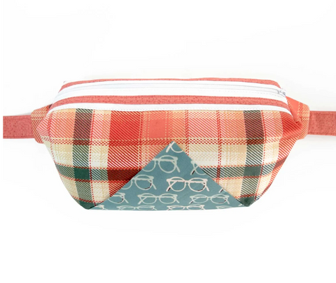 A plaid fanny pack with a white zipper and a blue triangle inset with glasses.