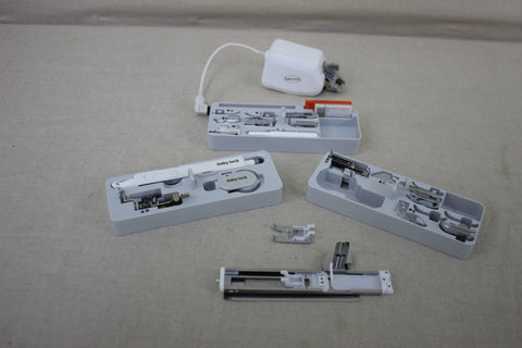 Baby Lock Solaris sewing and embroidery machine accessories are displayed on a light surface.