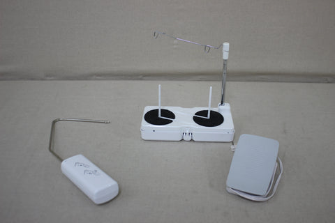 A white sewing machine accessory kit with a thread stand and foot pedal.