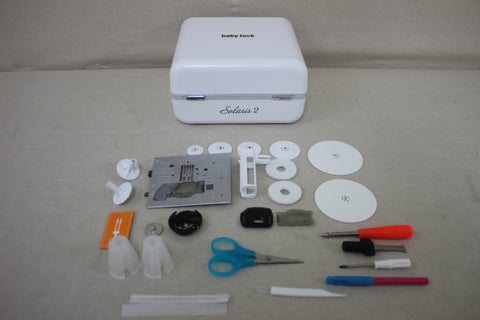 A white Baby Lock Solaris 2 sewing and embroidery machine with various accessories.