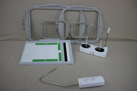 Various sewing and embroidery machine accessories are displayed on a light brown surface.