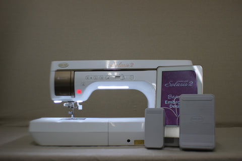 A white Baby Lock Solaris 2 sewing and embroidery machine with a tablet display.