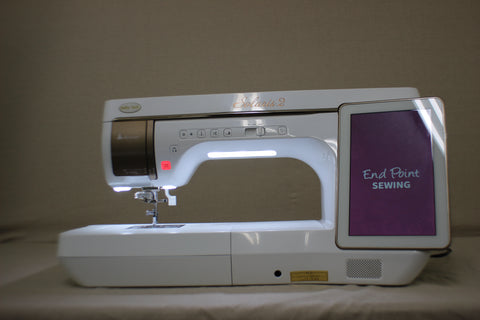 A white Baby Lock Solaris 2 sewing and embroidery machine with a lit screen.